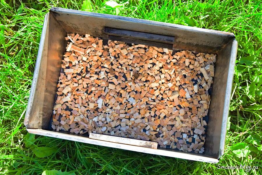 На дно коптильни засыпаем щепу
