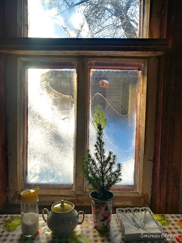 Морозные узоры на окне деревенского дома