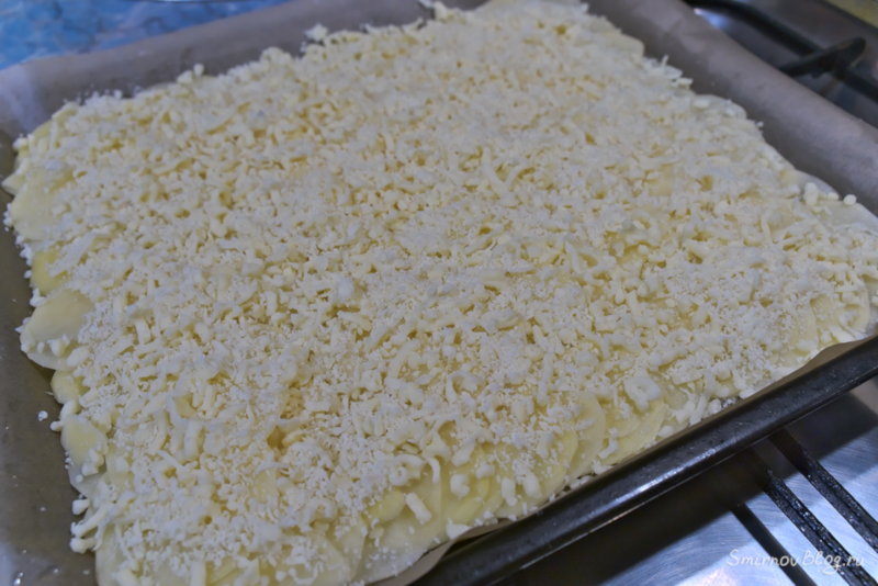 Процесс приготовления картофельного рулета с фаршем - посыпаем ломтики картофеля 1/3 тёртого сыра