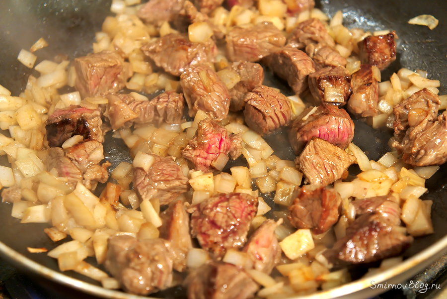 Обжариваем кусочки говядины с мелко нарезанным репчатым луком до золотистого цвета