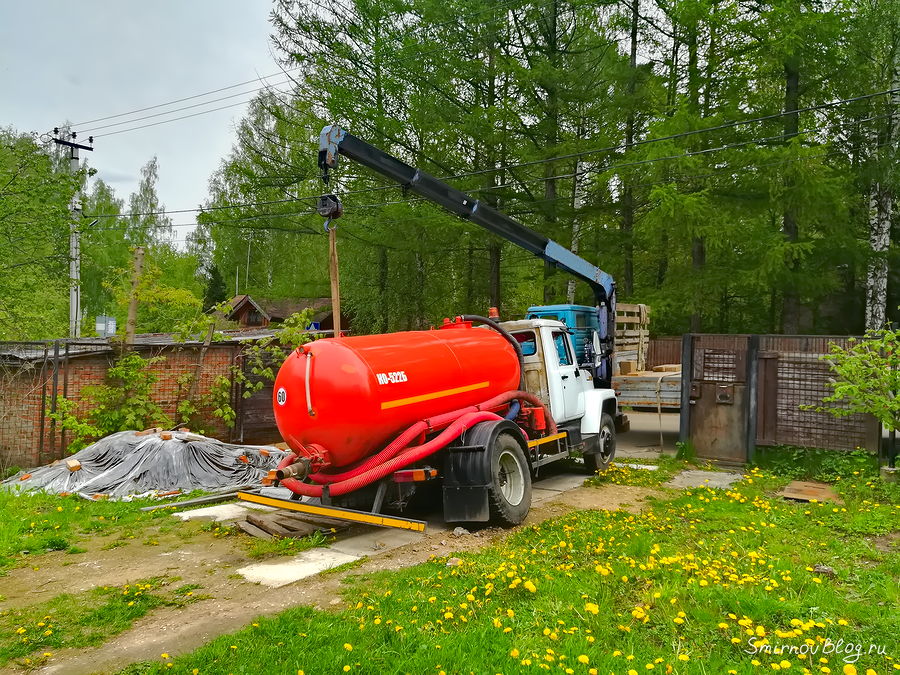 Манипулятор вытаскивает ассенизаторский грузовик